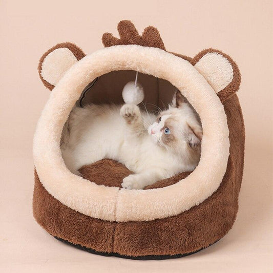 Cat playing with a toy inside a brown and beige pet bed shaped like a lion.